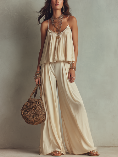 An Off White Flowing Top Paired With Thin Straps And Wide Leg Pants
